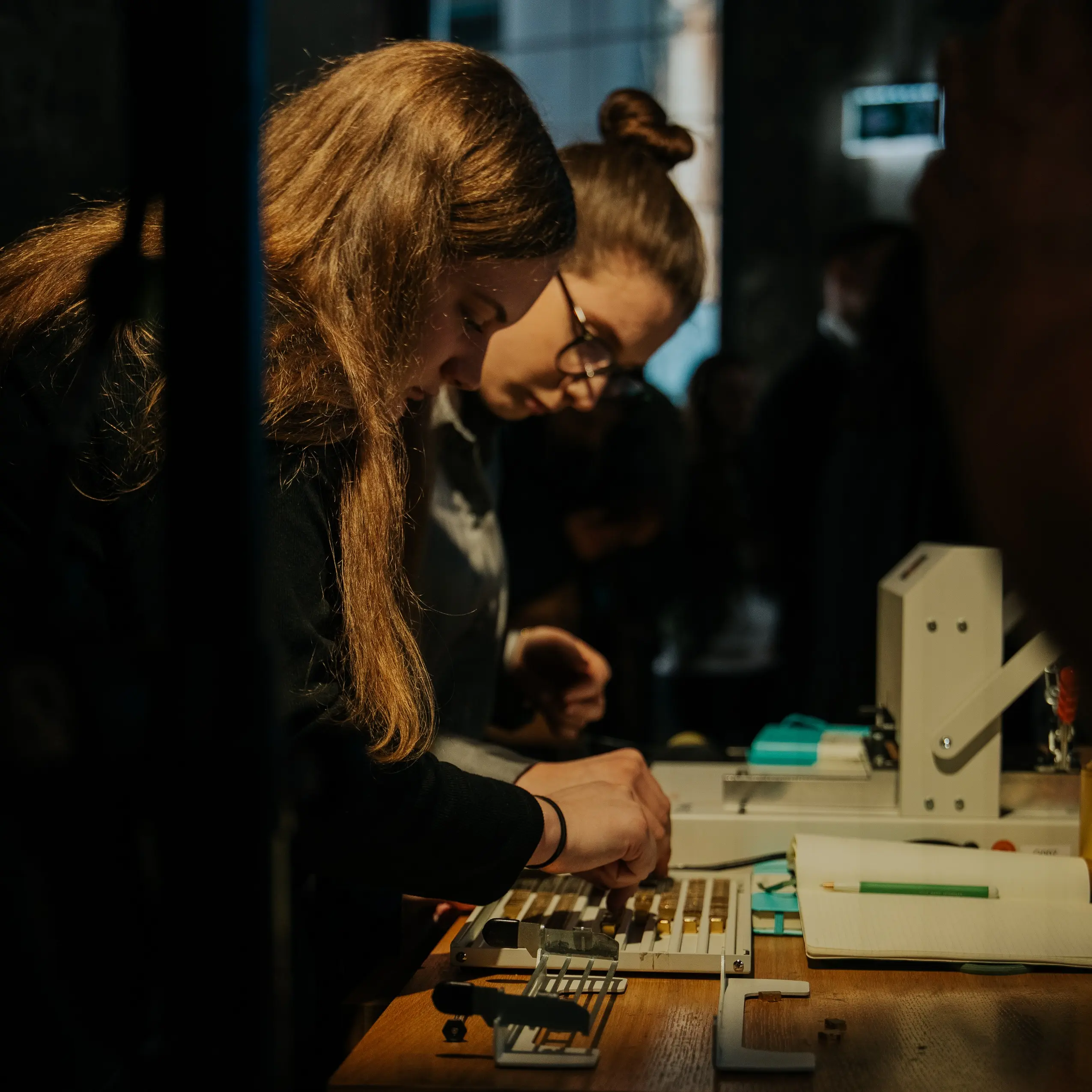 Spotify-All-Ears Live Event. Una persona coloca las letras, la otra estampa libretas en relieve.